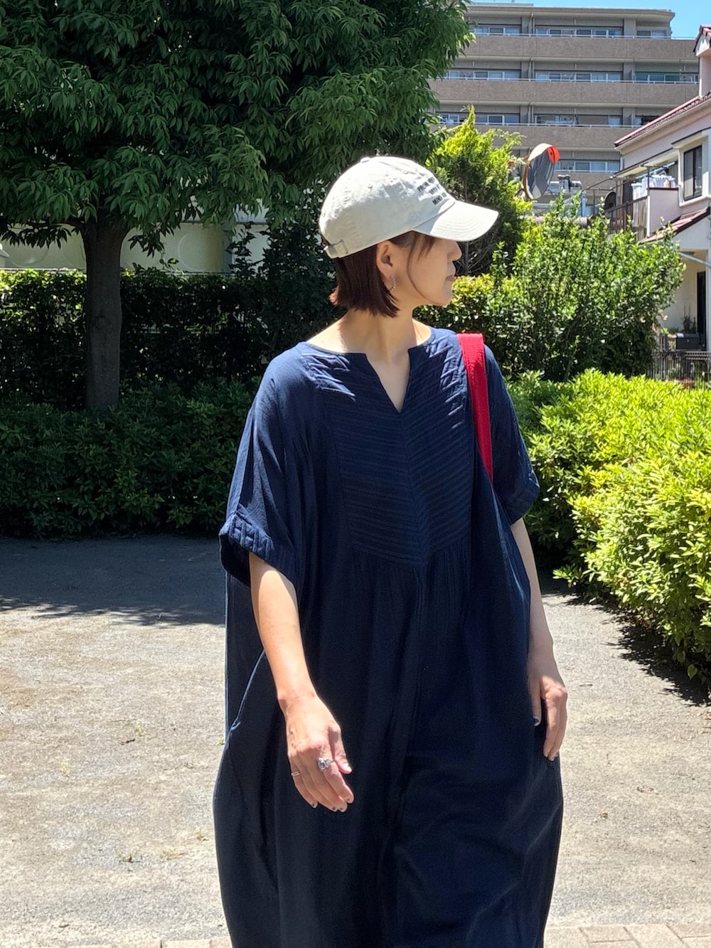 ブルー系のデニムパンツ、レッド系のトートバッグ、ブルー系のワンピースを着用したレディースの夏コーディネートの5枚目の写真