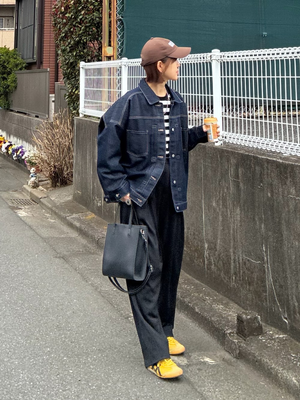 ブラック系のTシャツ/カットソー、ブルー系のデニムジャケット、ブラック系のスラックスを着用したレディースの春コーディネートの3枚目の写真