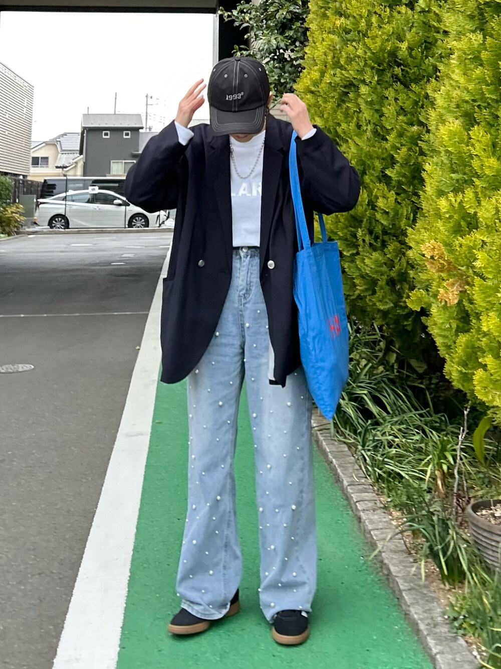 ホワイト系のTシャツ/カットソー、ブルー系のテーラードジャケット、ブルー系のデニムパンツを着用したレディースの春コーディネートの2枚目の写真