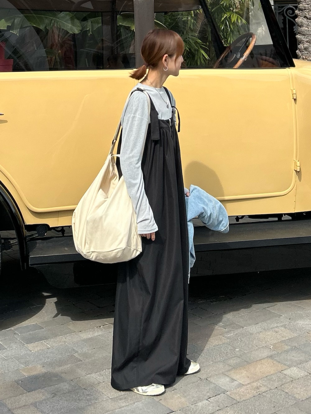 ブルー系のTシャツ/カットソー、ブラック系のサロペット/オーバーオール、ホワイト系のショルダーバッグを着用したレディースの冬コーディネートの2枚目の写真