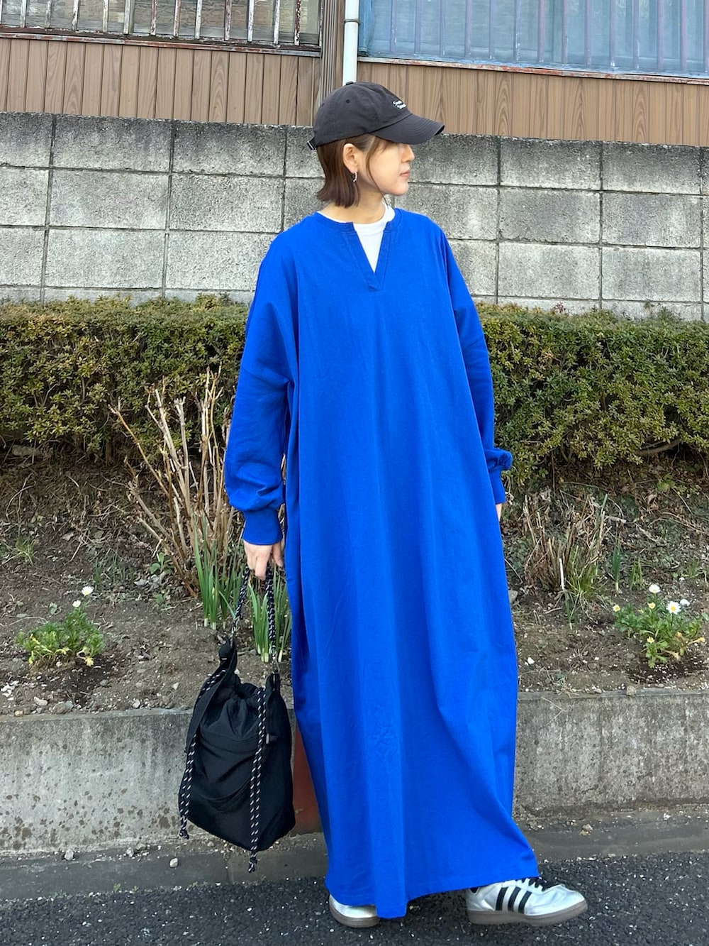 ブラック系のトートバッグ、ブルー系のワンピース、シルバー系のスニーカーを着用したレディースの冬コーディネートの3枚目の写真