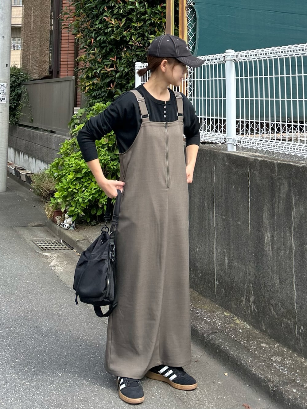 ブラック系のTシャツ/カットソー、ベージュ系のワンピース、ブラック系のショルダーバッグを着用したレディースの秋コーディネートの2枚目の写真