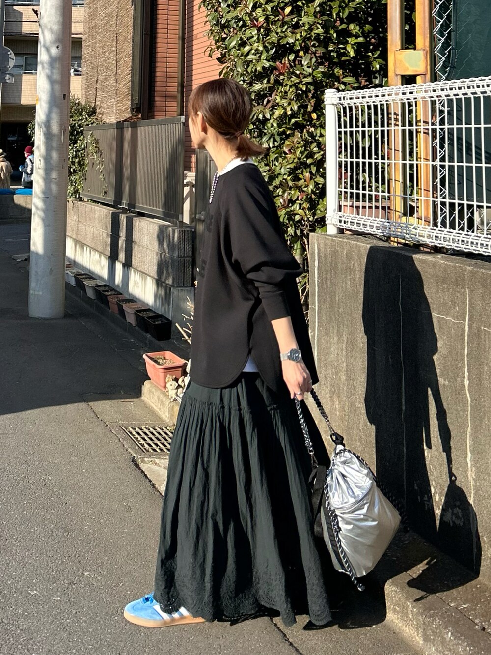ブラック系のTシャツ/カットソー、ブラック系のスカート、シルバー系のショルダーバッグを着用したレディースの冬コーディネートの2枚目の写真