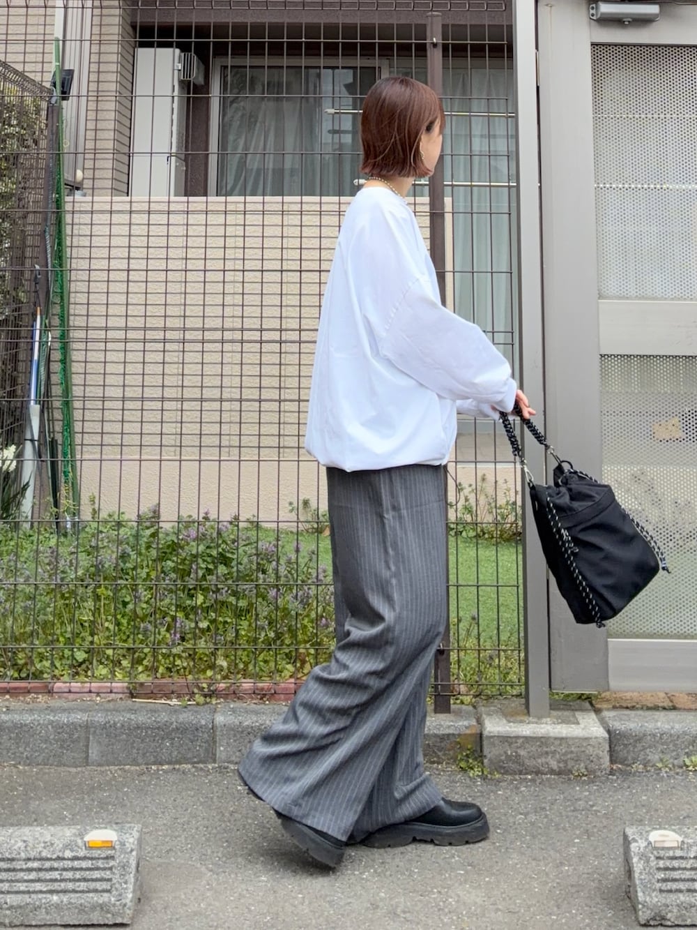 ホワイト系のTシャツ/カットソー、グレー系のその他パンツ、ブラック系のトートバッグを着用したレディースの春コーディネートの4枚目の写真