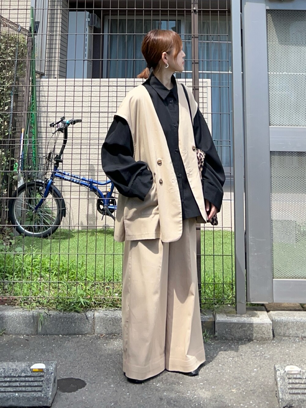 ベージュ系のベスト、ベージュ系のスラックス、ブラック系のシャツ/ブラウスを着用したレディースの秋コーディネートの2枚目の写真