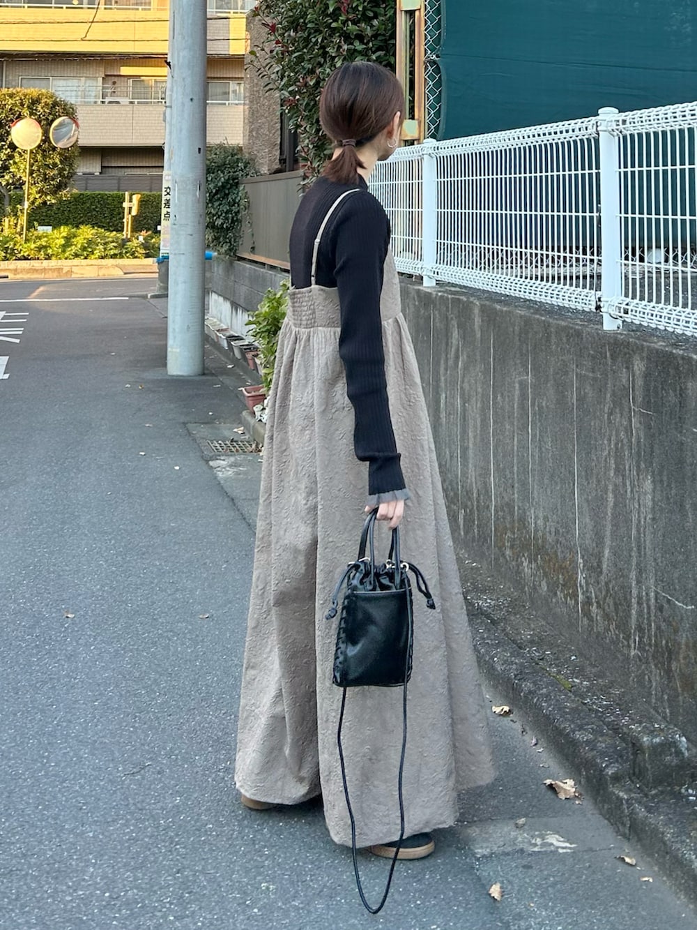 ベージュ系のワンピース、ブラック系のショルダーバッグを着用したレディースの冬コーディネートの3枚目の写真