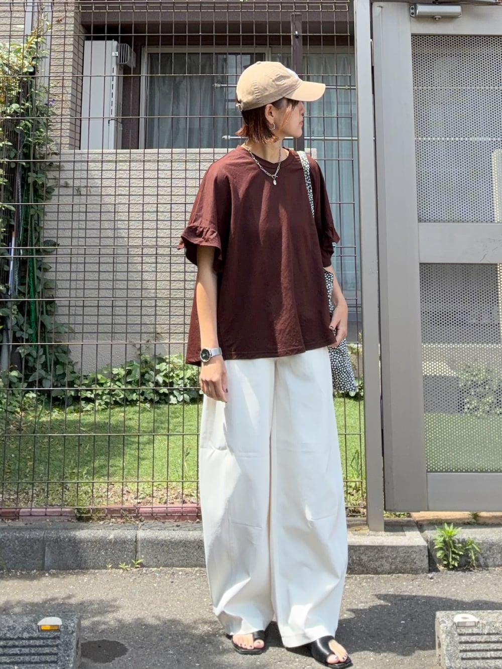 ブラウン系のTシャツ/カットソー、ホワイト系のその他パンツ、ブラック系のサンダルを着用したレディースの夏コーディネートの3枚目の写真