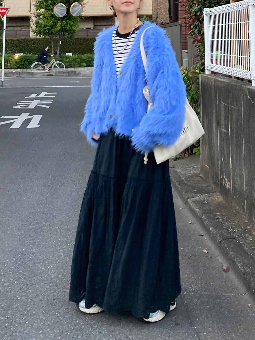 ブルー系のニット/セーター、ブラック系のTシャツ/カットソー、ブラック系のスカートを着用したレディースの秋コーディネートの3枚目の写真