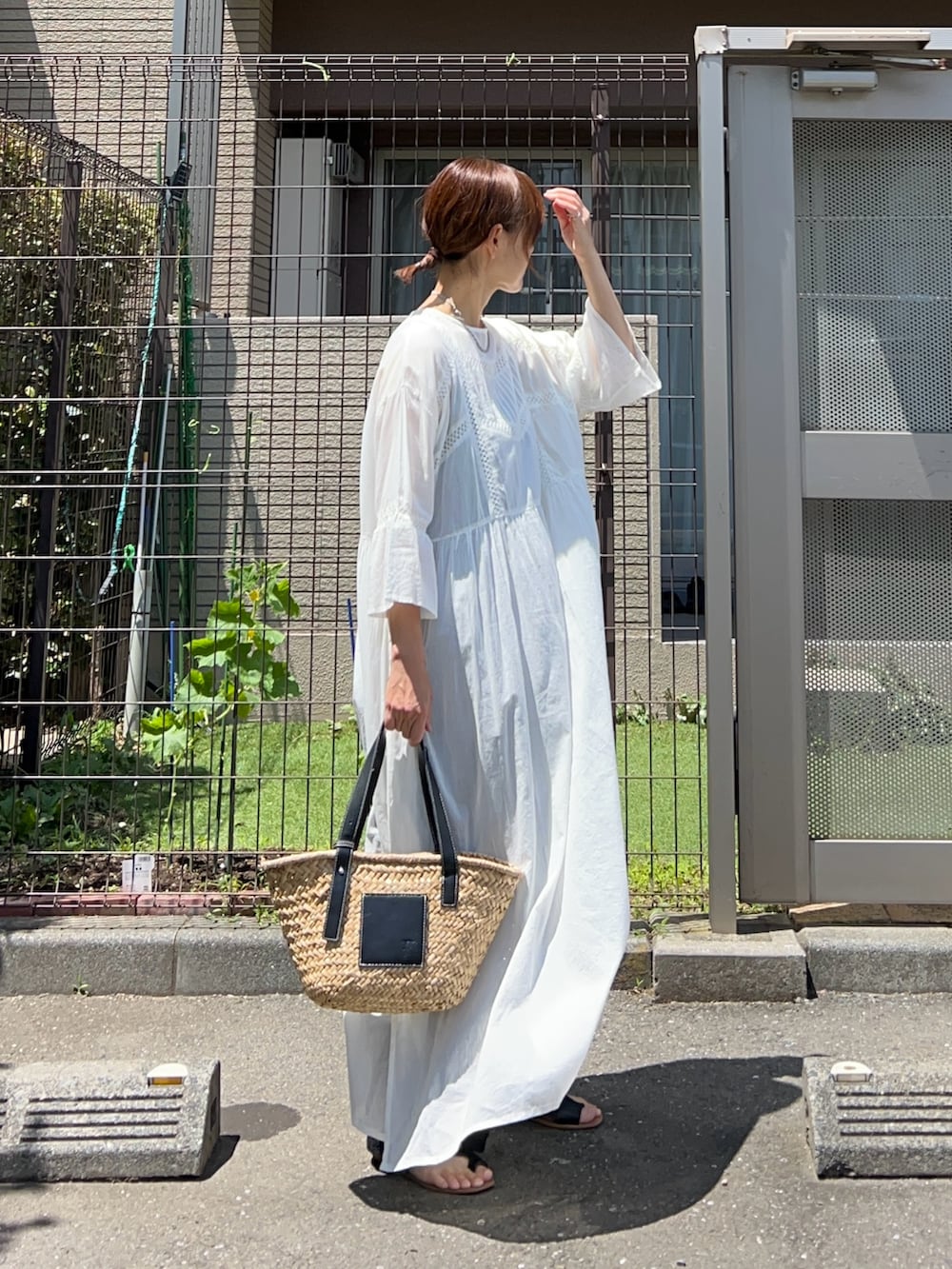 ホワイト系のワンピース、ブラック系のその他パンツ、ブラック系のかごバッグを着用したレディースの夏コーディネートの2枚目の写真