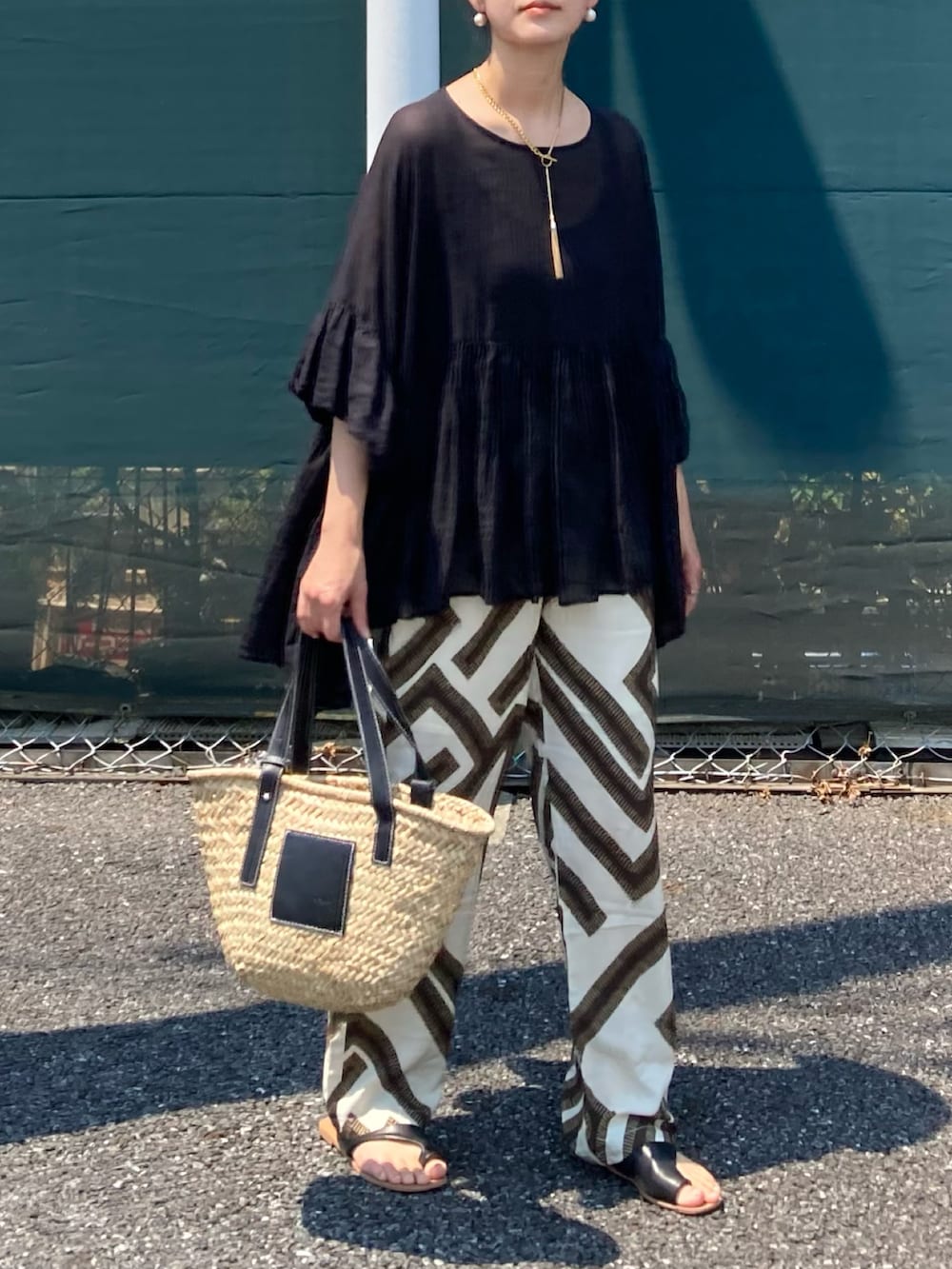 ブラック系のシャツ/ブラウス、ホワイト系のその他パンツ、ブラック系のサンダルを着用したレディースの夏コーディネートの2枚目の写真