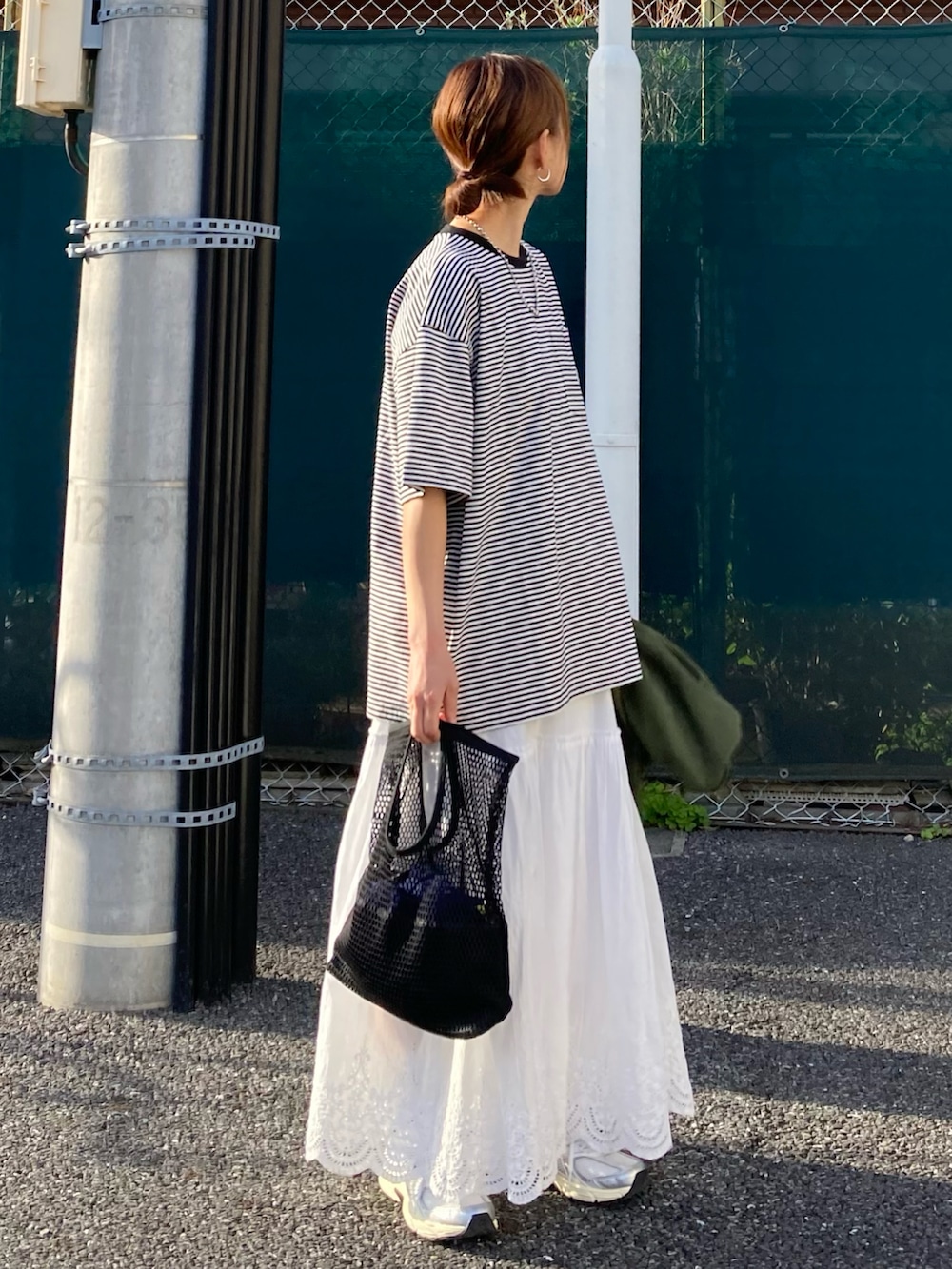 ブラック系のTシャツ/カットソー、ブルー系のデニムジャケット、ホワイト系のスカートを着用したレディースの春コーディネートの3枚目の写真