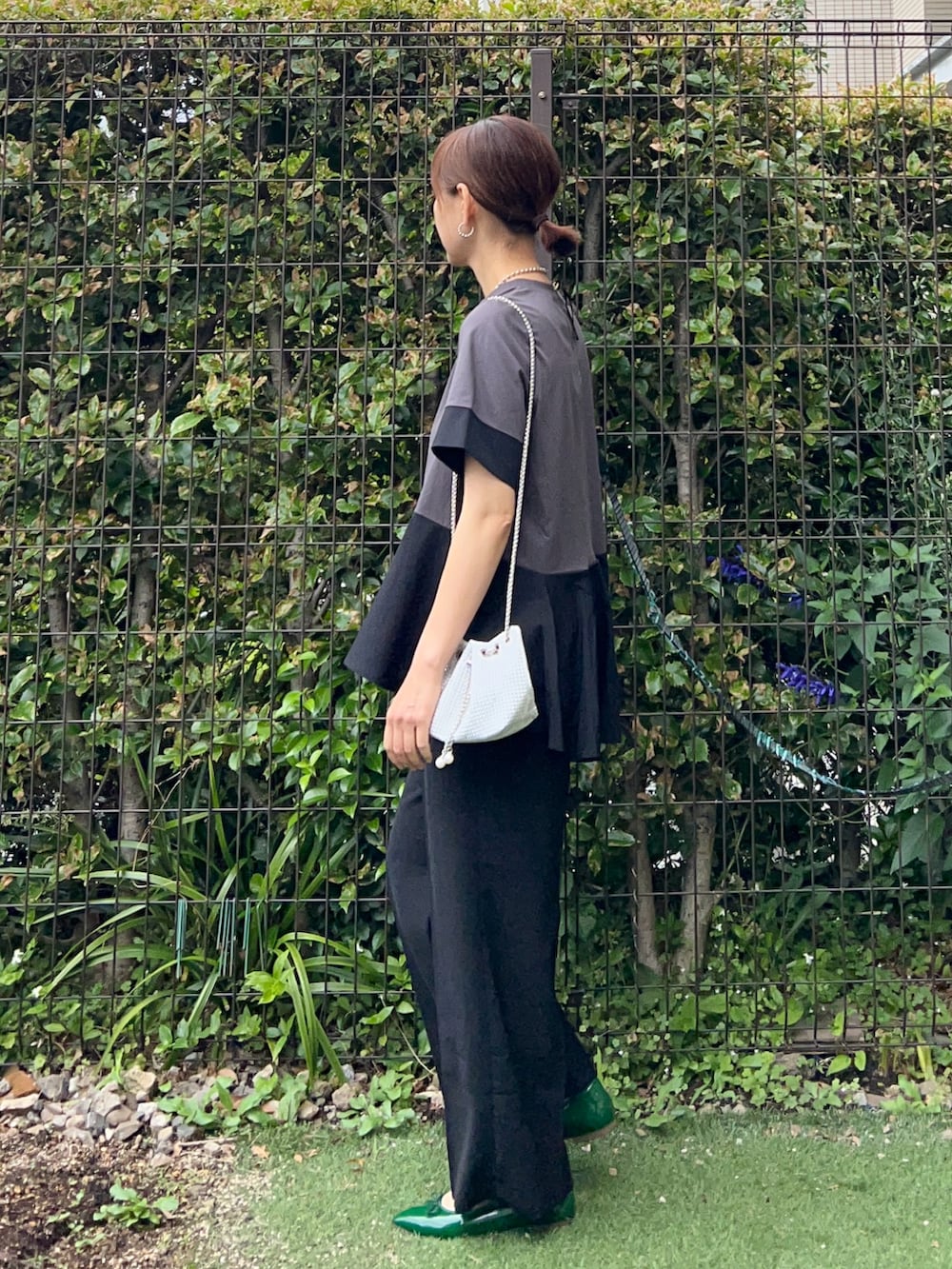 グレー系のTシャツ/カットソー、ブラック系のその他パンツ、ホワイト系のショルダーバッグを着用したレディースの春コーディネートの2枚目の写真