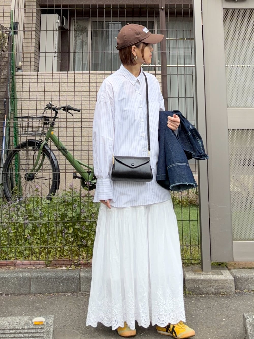 ホワイト系のスカート、ブルー系のデニムジャケット、ホワイト系のシャツ/ブラウスを着用したレディースの春コーディネートの2枚目の写真