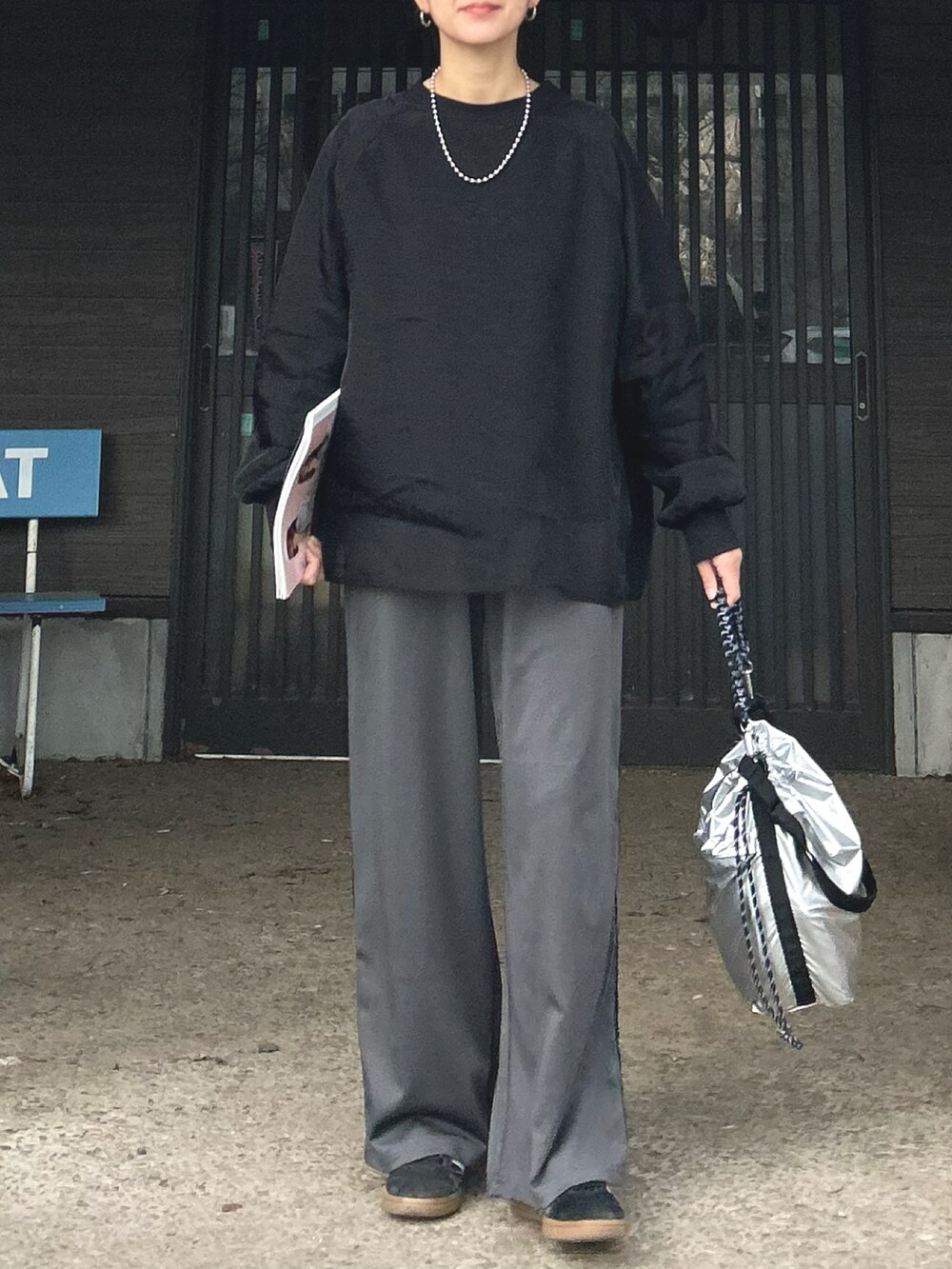 ブラック系のTシャツ/カットソー、グレー系のスラックス、シルバー系のトートバッグを着用したレディースの冬コーディネートの5枚目の写真