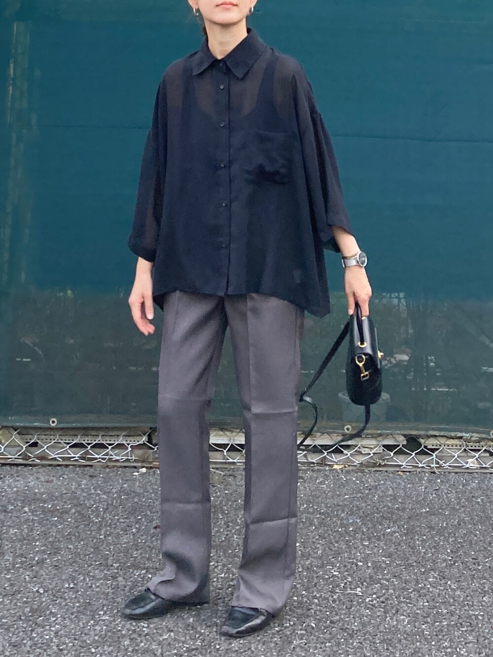 ブラック系のシャツ/ブラウス、グレー系のスラックス、ブラック系のショルダーバッグを着用したレディースの夏コーディネートの4枚目の写真