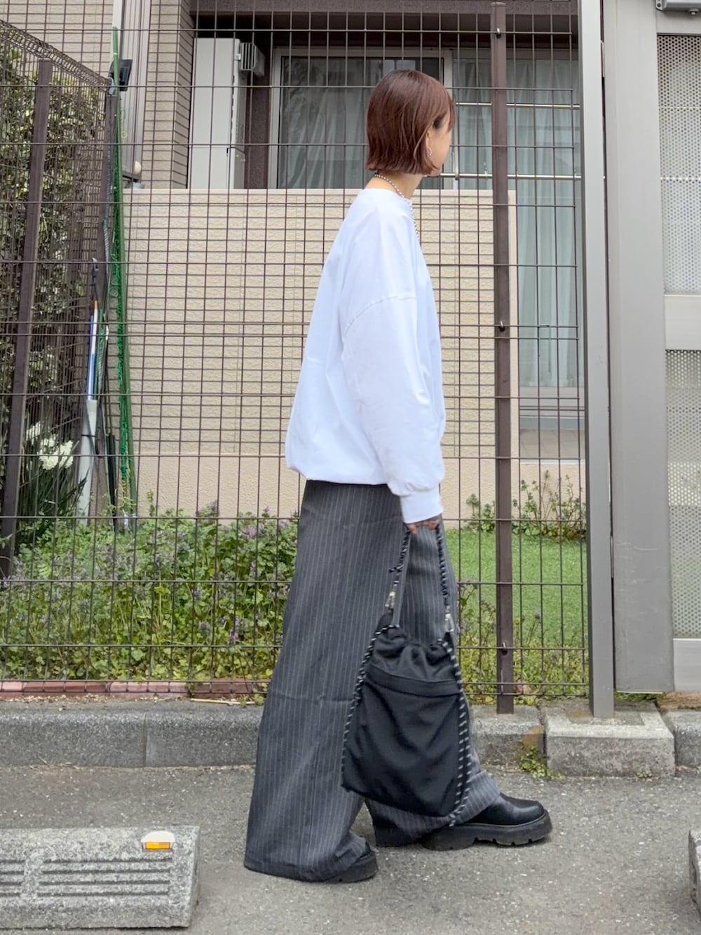 ホワイト系のTシャツ/カットソー、グレー系のその他パンツ、ブラック系のトートバッグを着用したレディースの春コーディネートの3枚目の写真