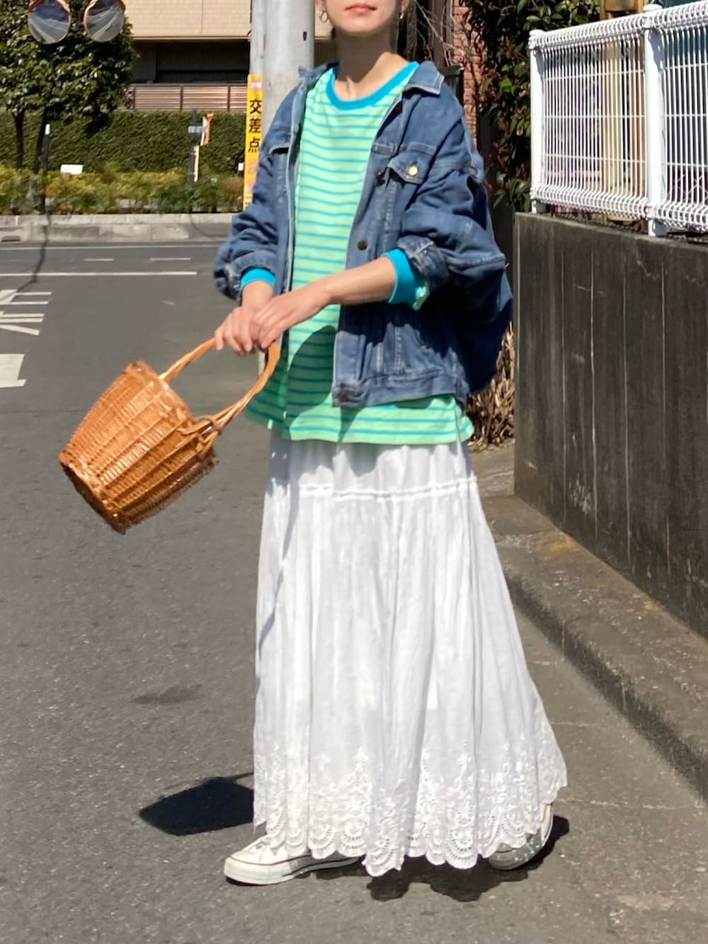 グリーン系のTシャツ/カットソー、ホワイト系のスカート、ホワイト系のスニーカーを着用したレディースの春コーディネートの3枚目の写真