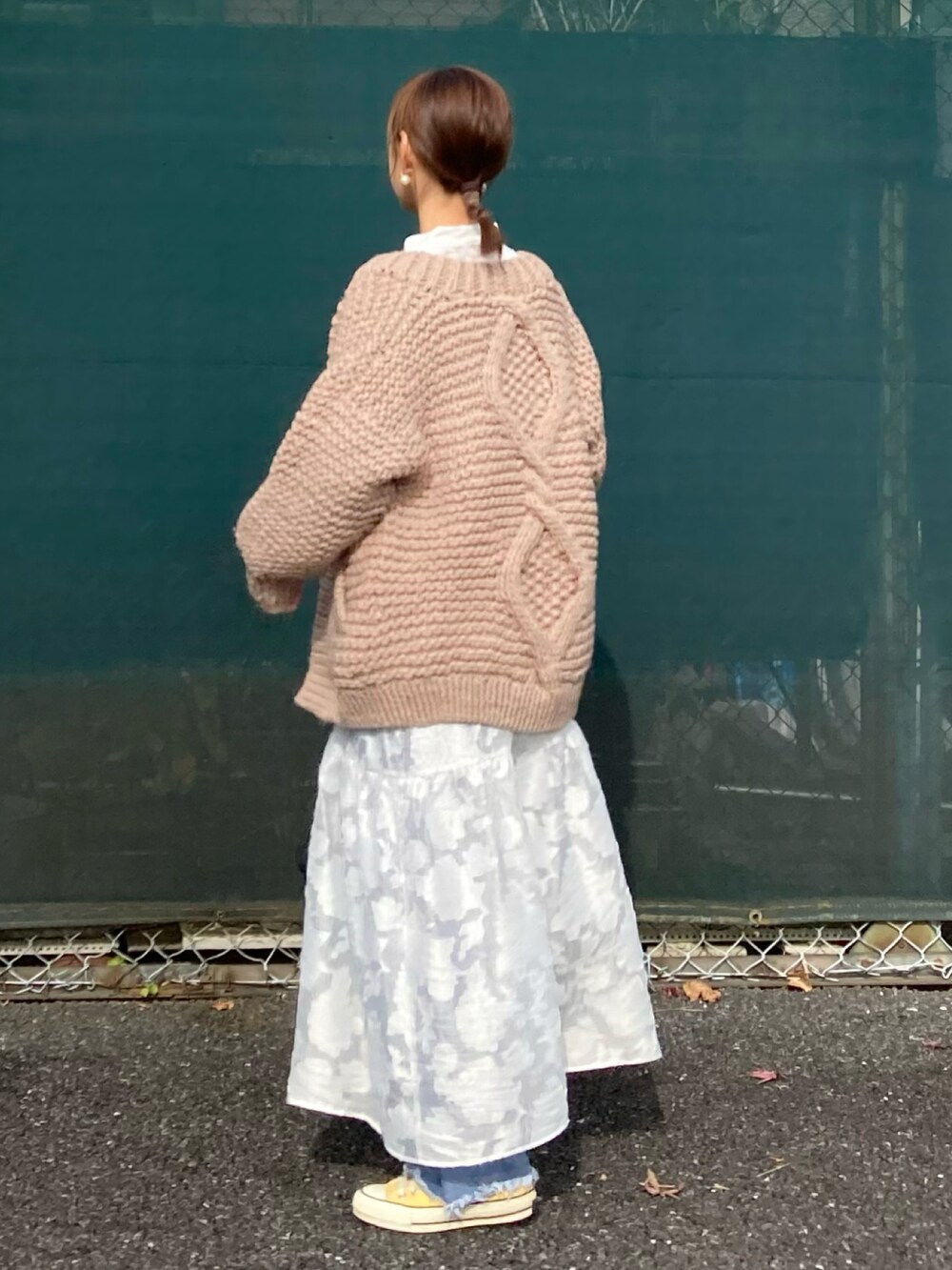 ホワイト系のワンピース、ベージュ系のカーディガン/ボレロ、ブルー系のデニムパンツを着用したレディースの秋コーディネートの4枚目の写真