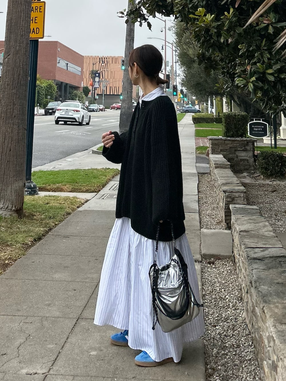 ブラック系のニット/セーター、ホワイト系のシャツワンピース、シルバー系のトートバッグを着用したレディースの冬コーディネートの4枚目の写真