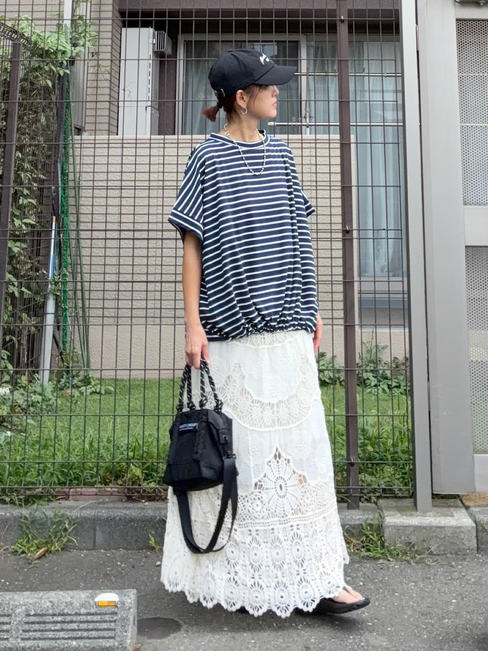 ブルー系のTシャツ/カットソー、ホワイト系のスカート、ブラック系のトートバッグを着用したレディースの秋コーディネートの3枚目の写真