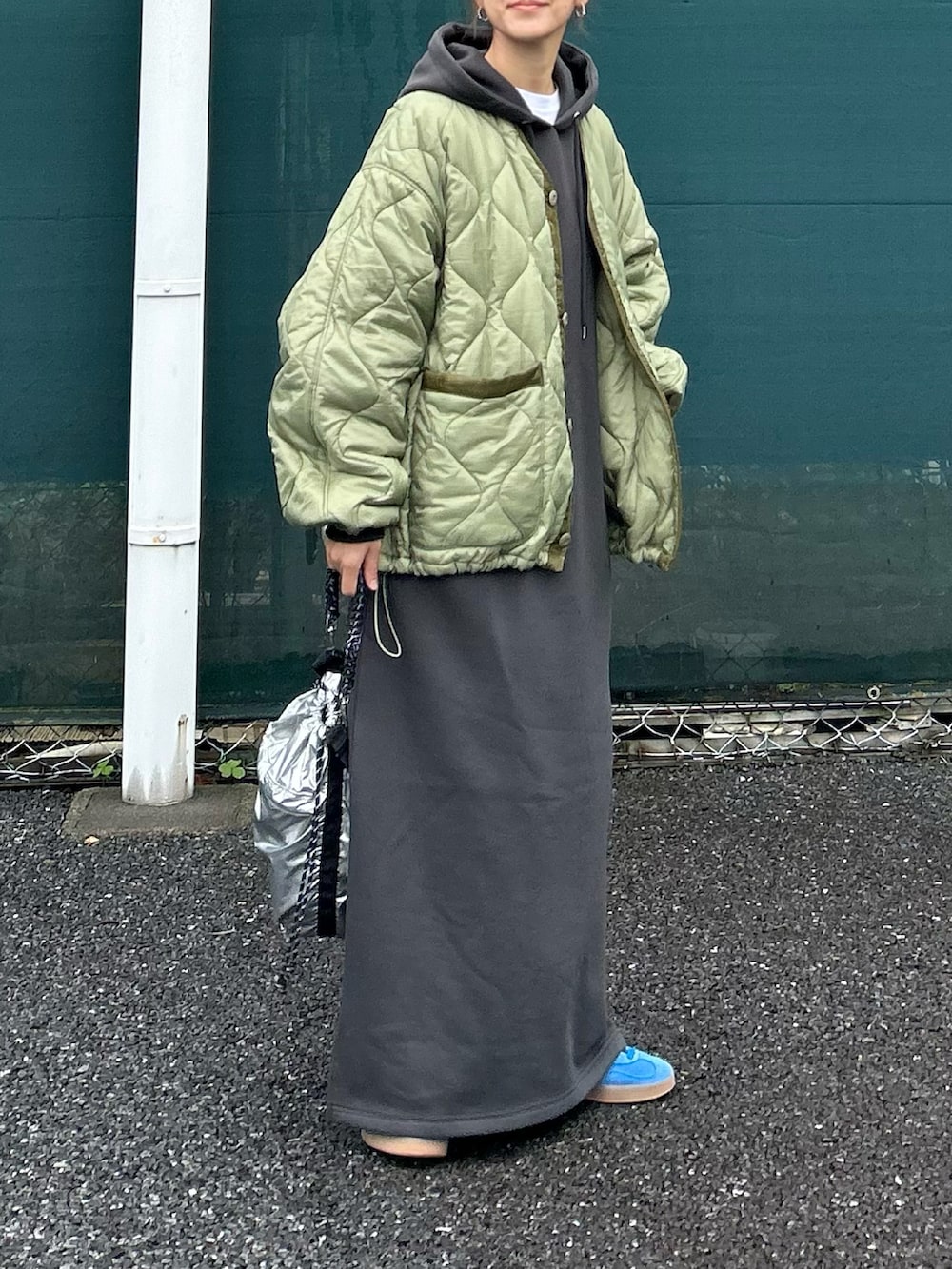 グレー系のワンピース、グリーン系のノーカラージャケット、シルバー系のトートバッグを着用したレディースの秋コーディネートの3枚目の写真