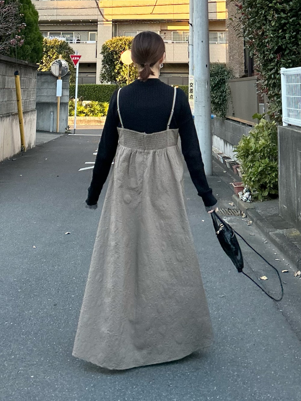 ベージュ系のワンピース、ブラック系のショルダーバッグを着用したレディースの冬コーディネートの4枚目の写真