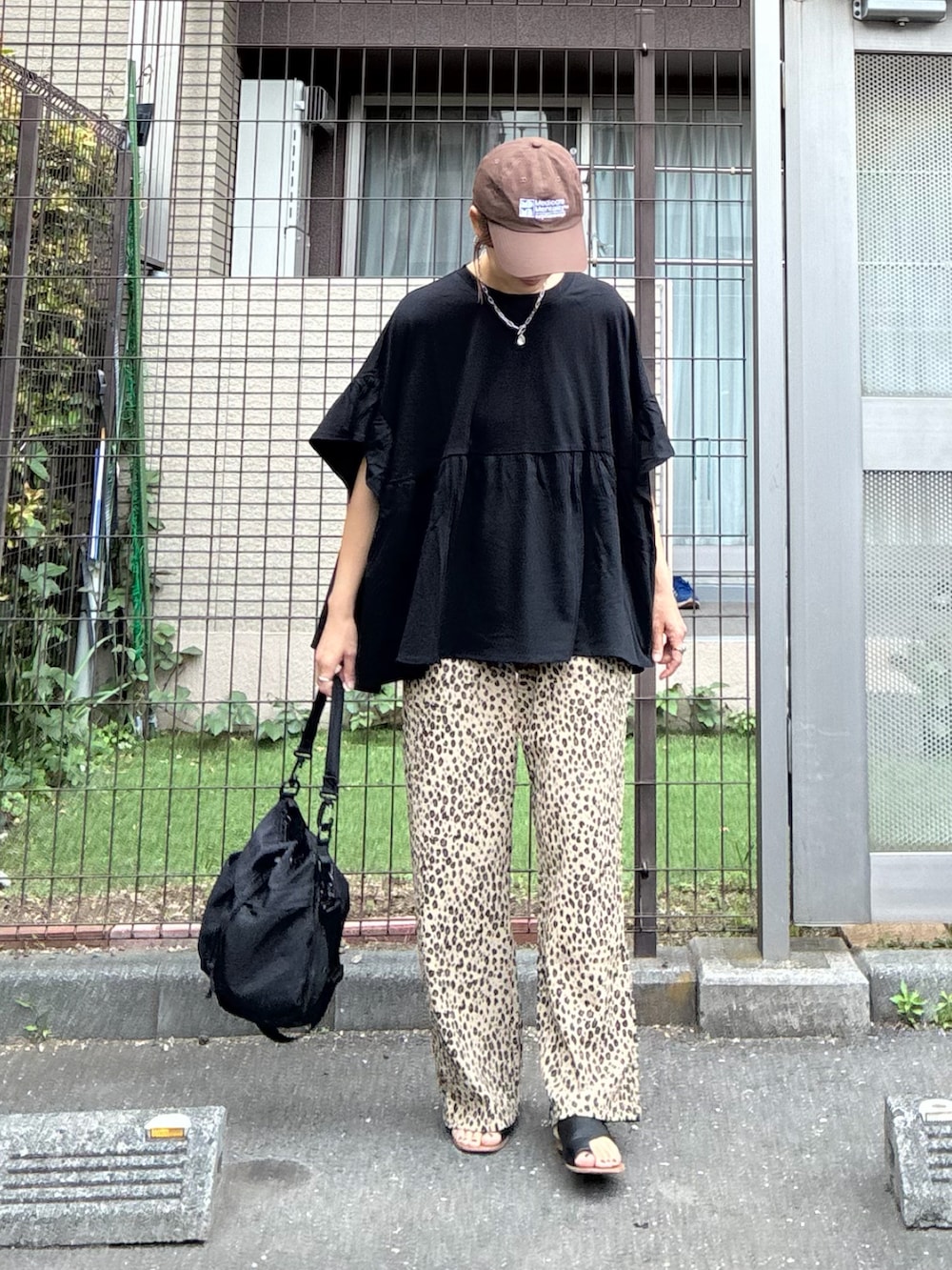 ブラック系のTシャツ/カットソー、ベージュ系のスウェットパンツ、ブラック系のショルダーバッグを着用したレディースの春コーディネートの3枚目の写真