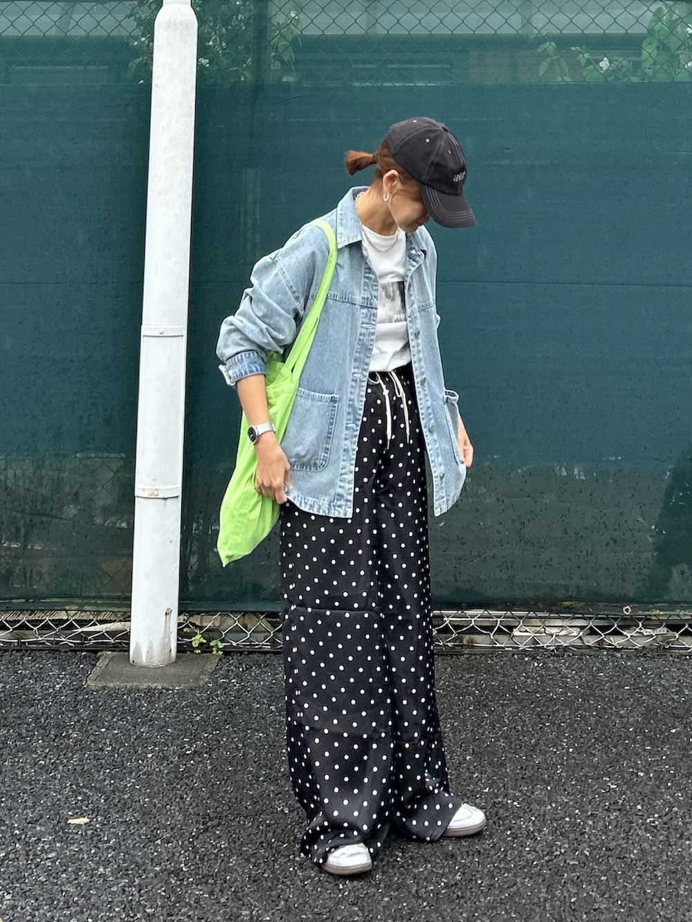 ブラック系のスラックス、ブルー系のデニムジャケット、ホワイト系のTシャツ/カットソーを着用したレディースの夏コーディネートの2枚目の写真