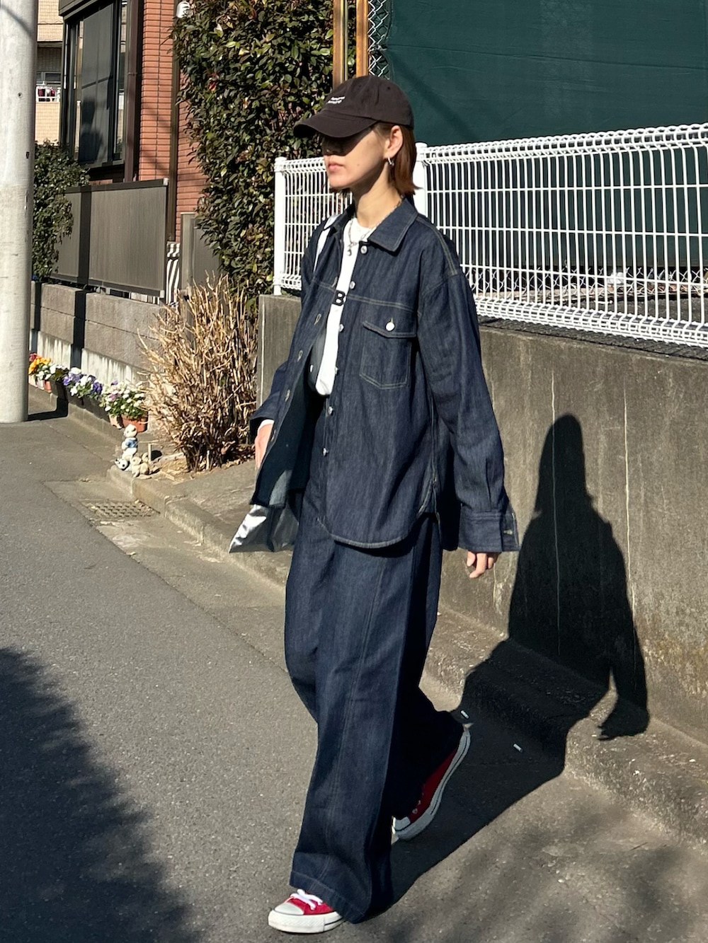 ブルー系のシャツ/ブラウス、ホワイト系のTシャツ/カットソー、シルバー系のクラッチバッグを着用したレディースの冬コーディネートの4枚目の写真