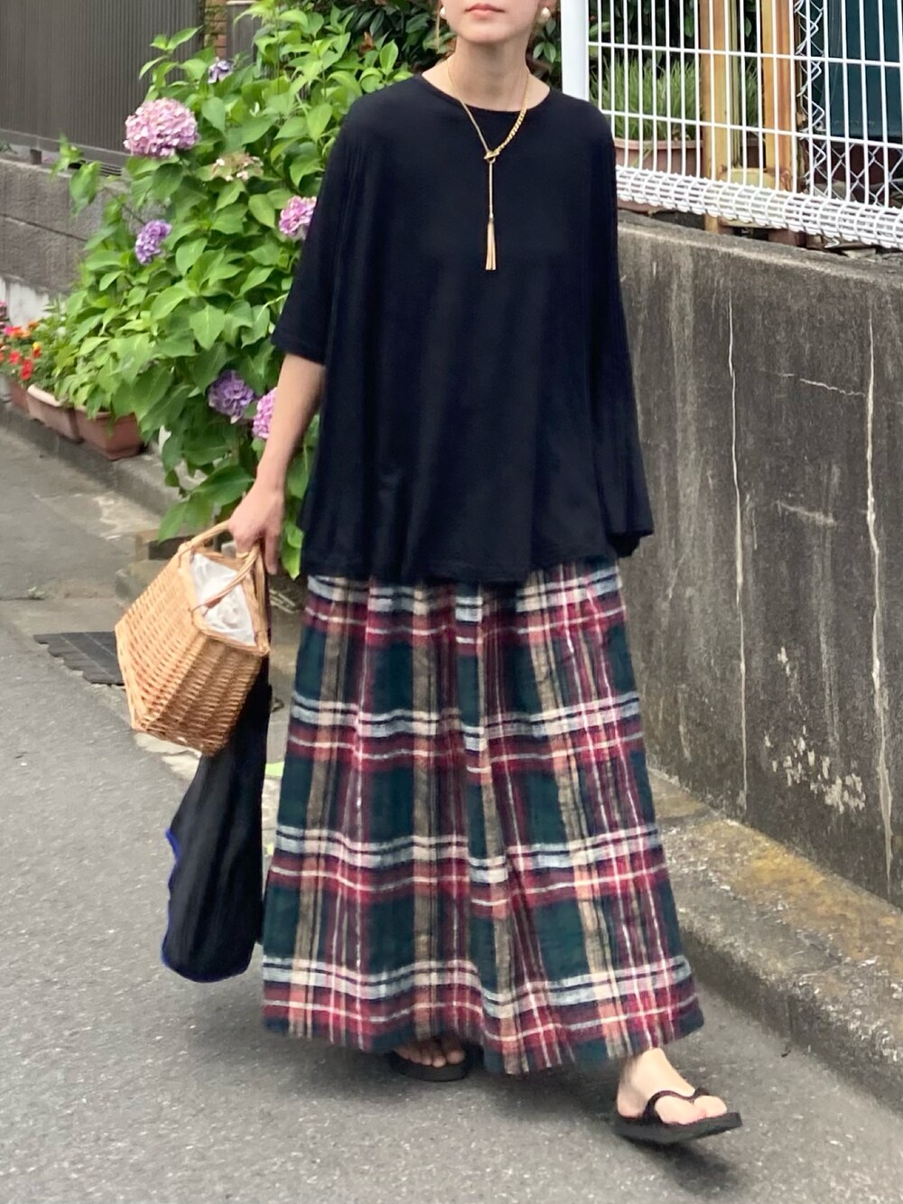 ブラック系のTシャツ/カットソー、グリーン系のスカート、ブラック系のエコバッグ/サブバッグを着用したレディースの夏コーディネートの2枚目の写真