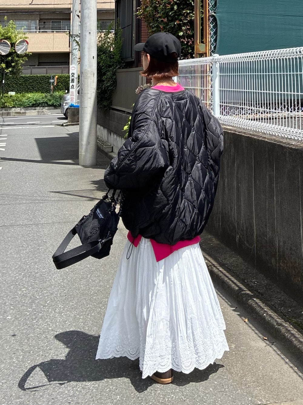 ブラック系のトートバッグ、ブラック系のブルゾン、ブラック系のキャップを着用したレディースの夏コーディネートの5枚目の写真
