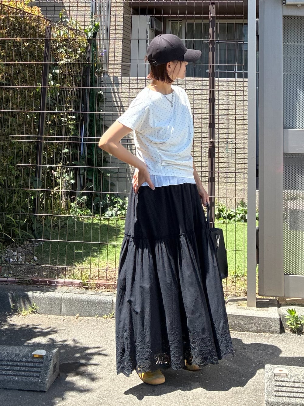 ホワイト系のTシャツ/カットソー、ブラック系のスカートを着用したレディースの夏コーディネートの2枚目の写真