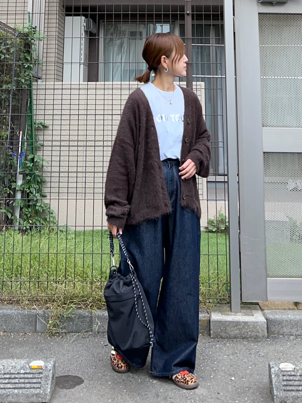 ホワイト系のTシャツ/カットソー、ブラウン系のカーディガン/ボレロ、ブルー系のデニムパンツを着用したレディースの秋コーディネートの3枚目の写真