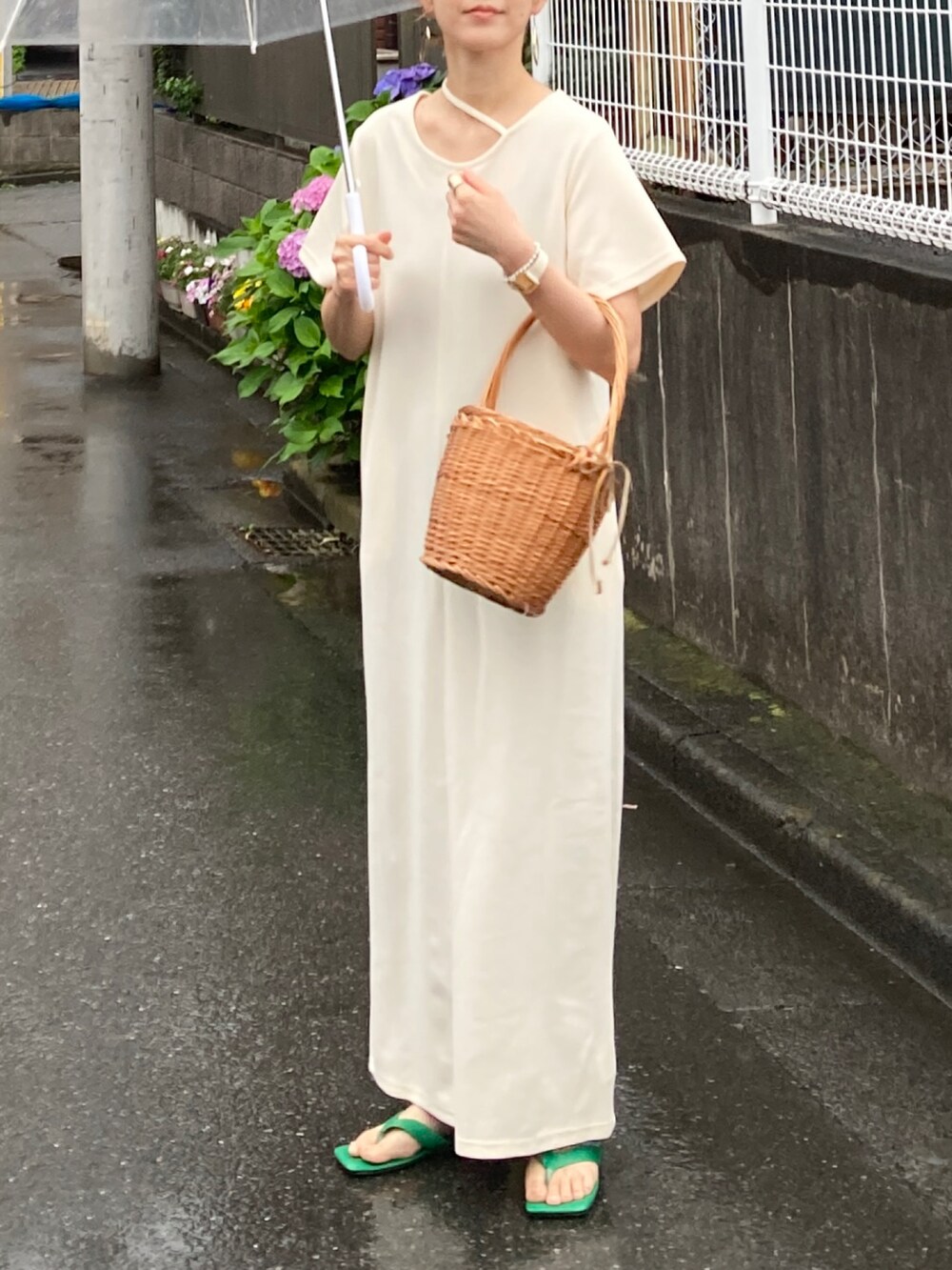 ホワイト系のワンピース、ブルー系のデニムパンツ、グリーン系のサンダルを着用したレディースの夏コーディネートの2枚目の写真