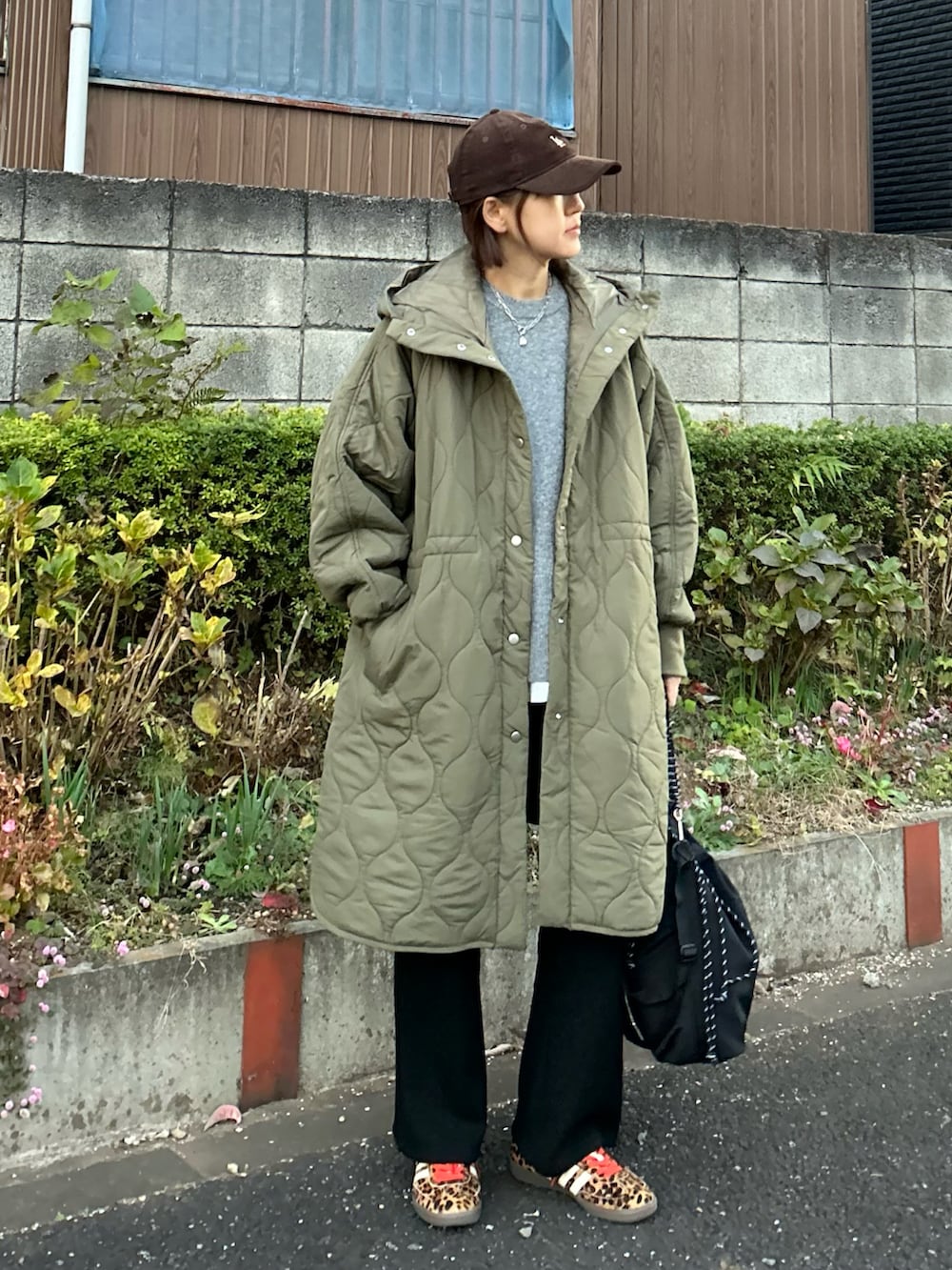 グレー系のニット/セーター、グリーン系のその他アウター、ブラック系のその他パンツを着用したレディースの冬コーディネートの5枚目の写真