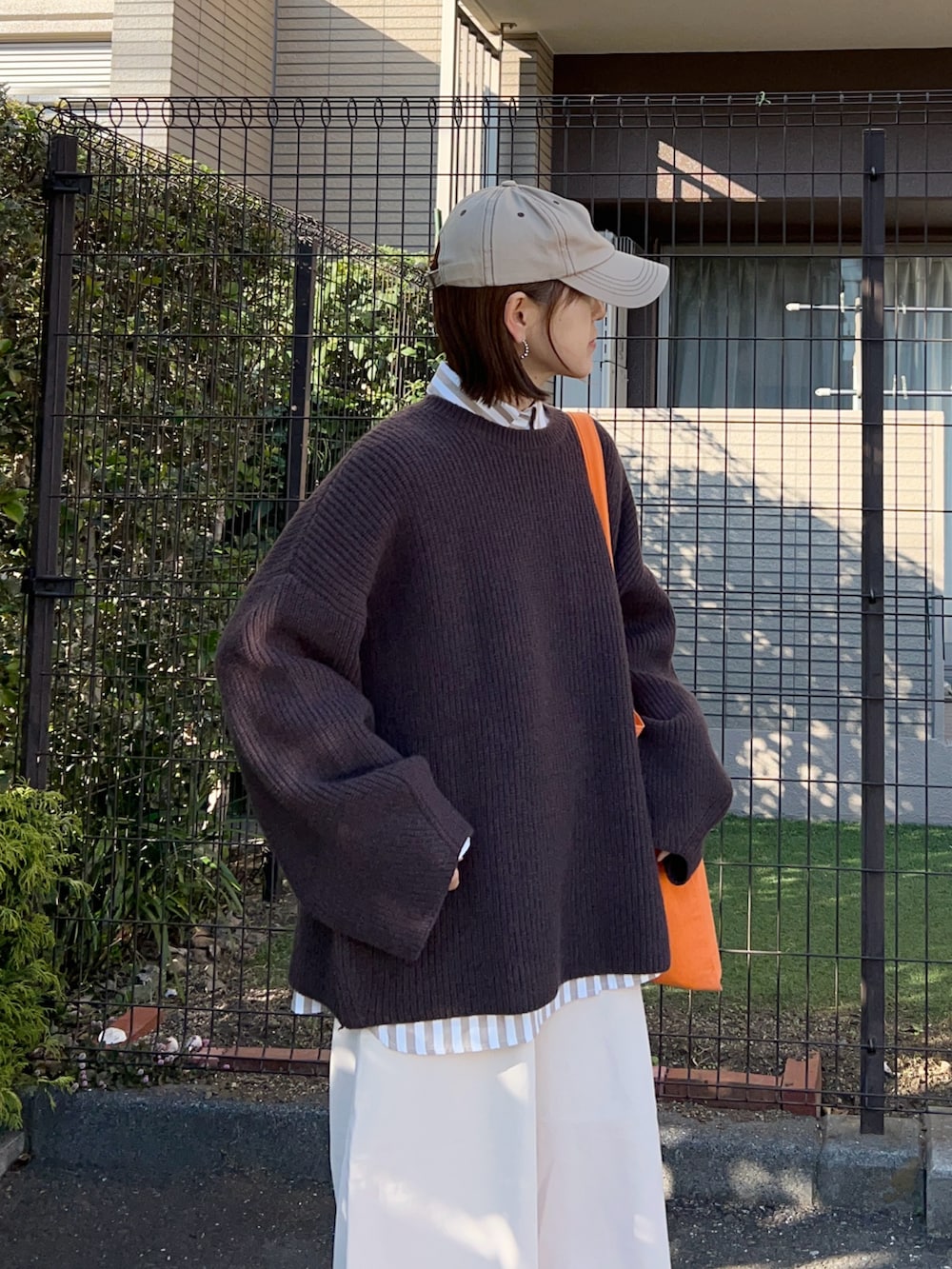 ブラウン系のニット/セーター、ベージュ系のシャツ/ブラウス、ホワイト系のその他パンツを着用したレディースの春コーディネートの3枚目の写真