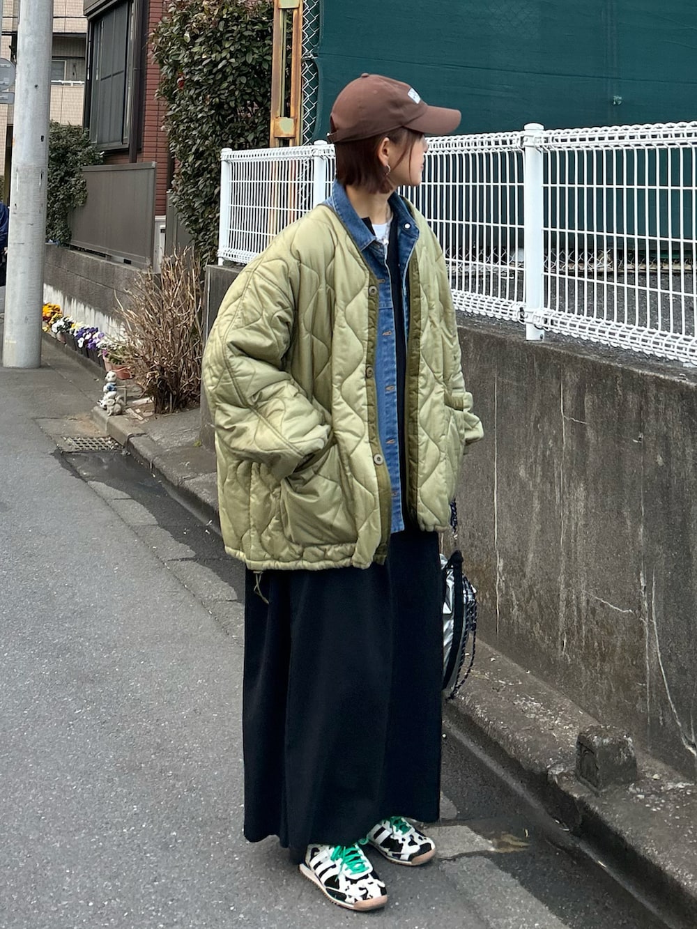 ブラック系のワンピース、グリーン系のブルゾン、ブルー系のデニムジャケットを着用したレディースの冬コーディネートの2枚目の写真