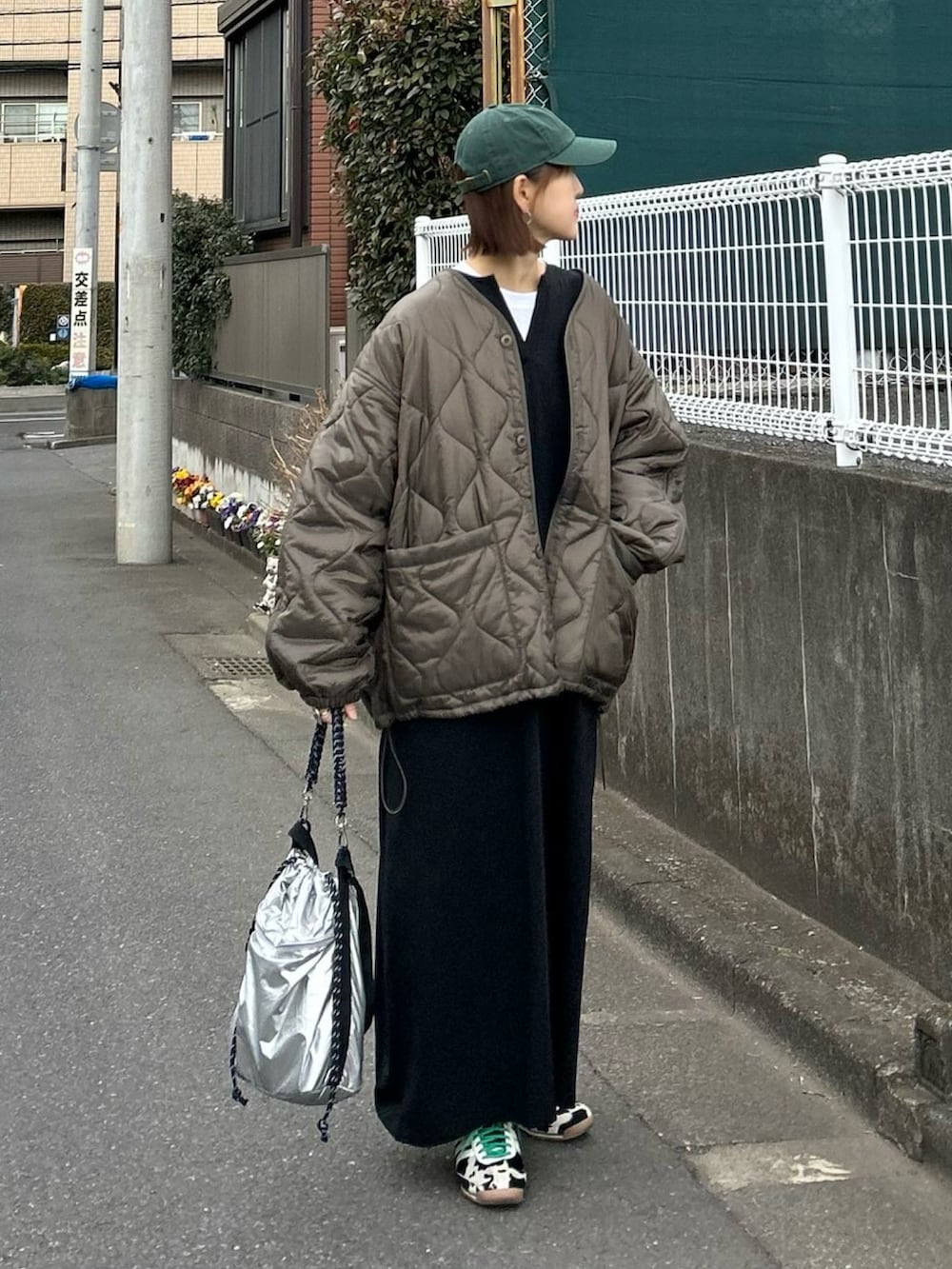 ブラウン系のブルゾン、シルバー系のトートバッグ、ブラック系のスニーカーを着用したレディースの冬コーディネートの3枚目の写真