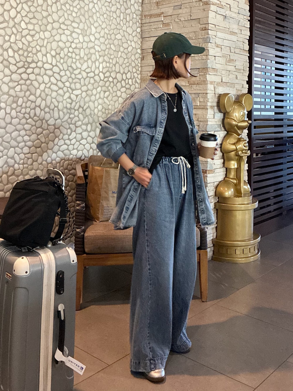 ブルー系のシャツ/ブラウス、ブラック系のショルダーバッグ、ブラック系のTシャツ/カットソーを着用したレディースの春コーディネートの2枚目の写真