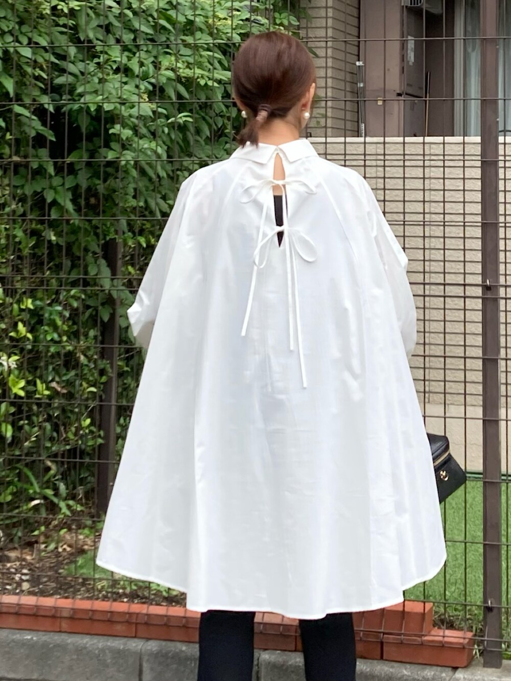 ホワイト系のシャツ/ブラウス、ブラック系のショルダーバッグ、ブラック系のパンツを着用したレディースの秋コーディネートの5枚目の写真