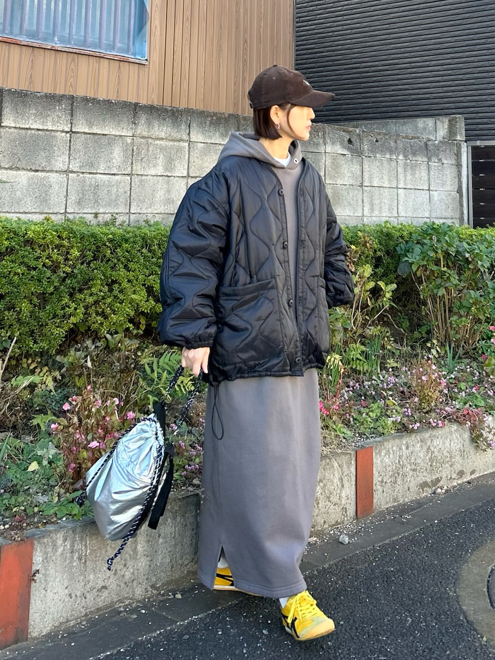 ブラック系のブルゾン、グレー系のワンピース、シルバー系のトートバッグを着用したレディースの冬コーディネートの4枚目の写真