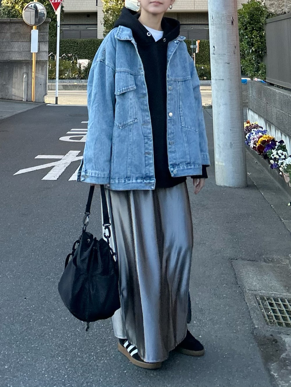 ブルー系のデニムジャケット、シルバー系のスカート、ブラック系のショルダーバッグを着用したレディースの春コーディネートの4枚目の写真