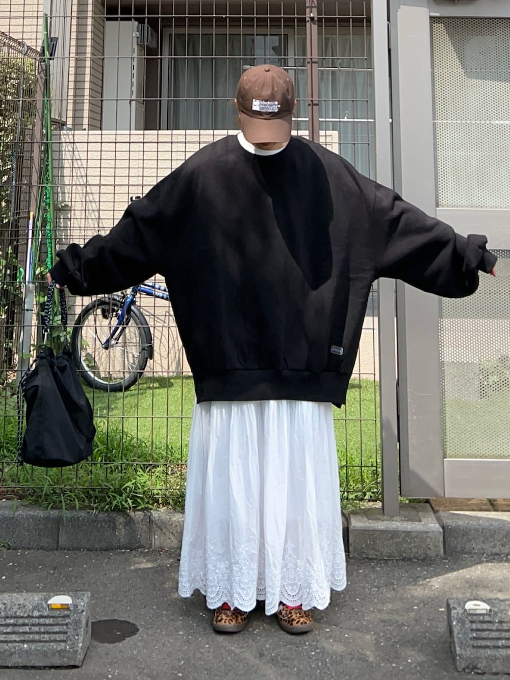 ブラック系のトートバッグ、ブラック系のスウェット、ホワイト系のスカートを着用したレディースの秋コーディネートの3枚目の写真