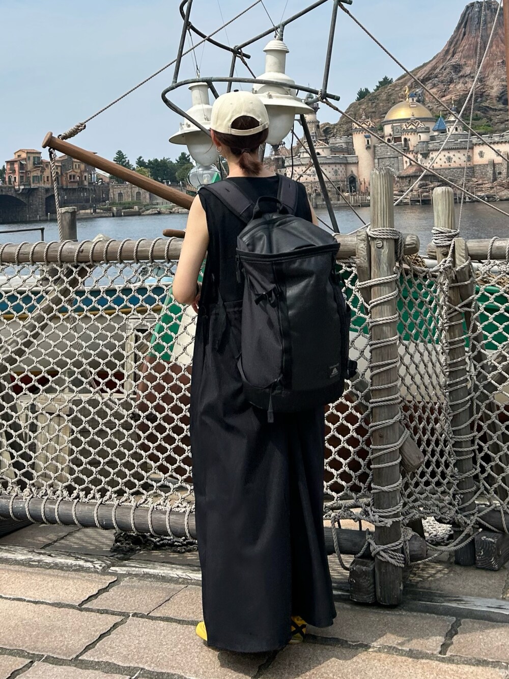 ブラック系のワンピース、イエロー系のスニーカー、ブラック系のキャップを着用したレディースの夏コーディネートの4枚目の写真