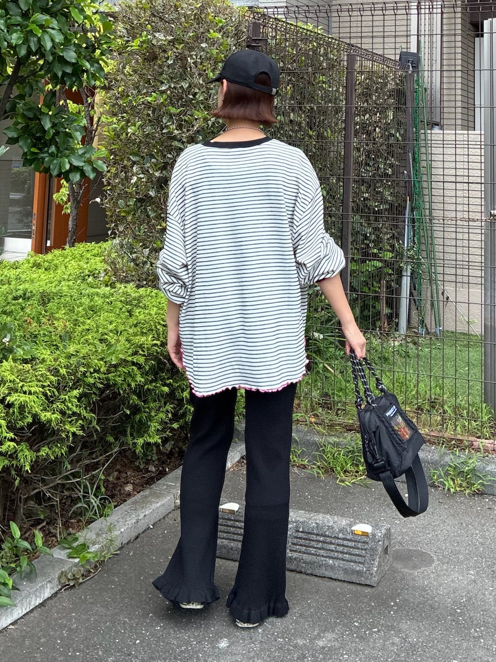 ホワイト系のTシャツ/カットソー、ブラック系のその他パンツ、ブラック系のトートバッグを着用したレディースの秋コーディネートの3枚目の写真