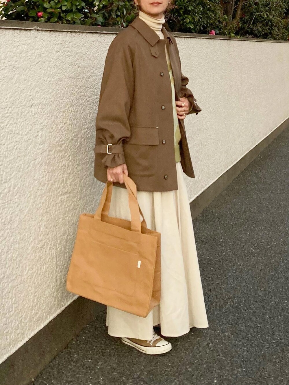 ベージュ系のブルゾン、グリーン系のニット/セーター、ベージュ系のトートバッグを着用したレディースの冬コーディネートの3枚目の写真