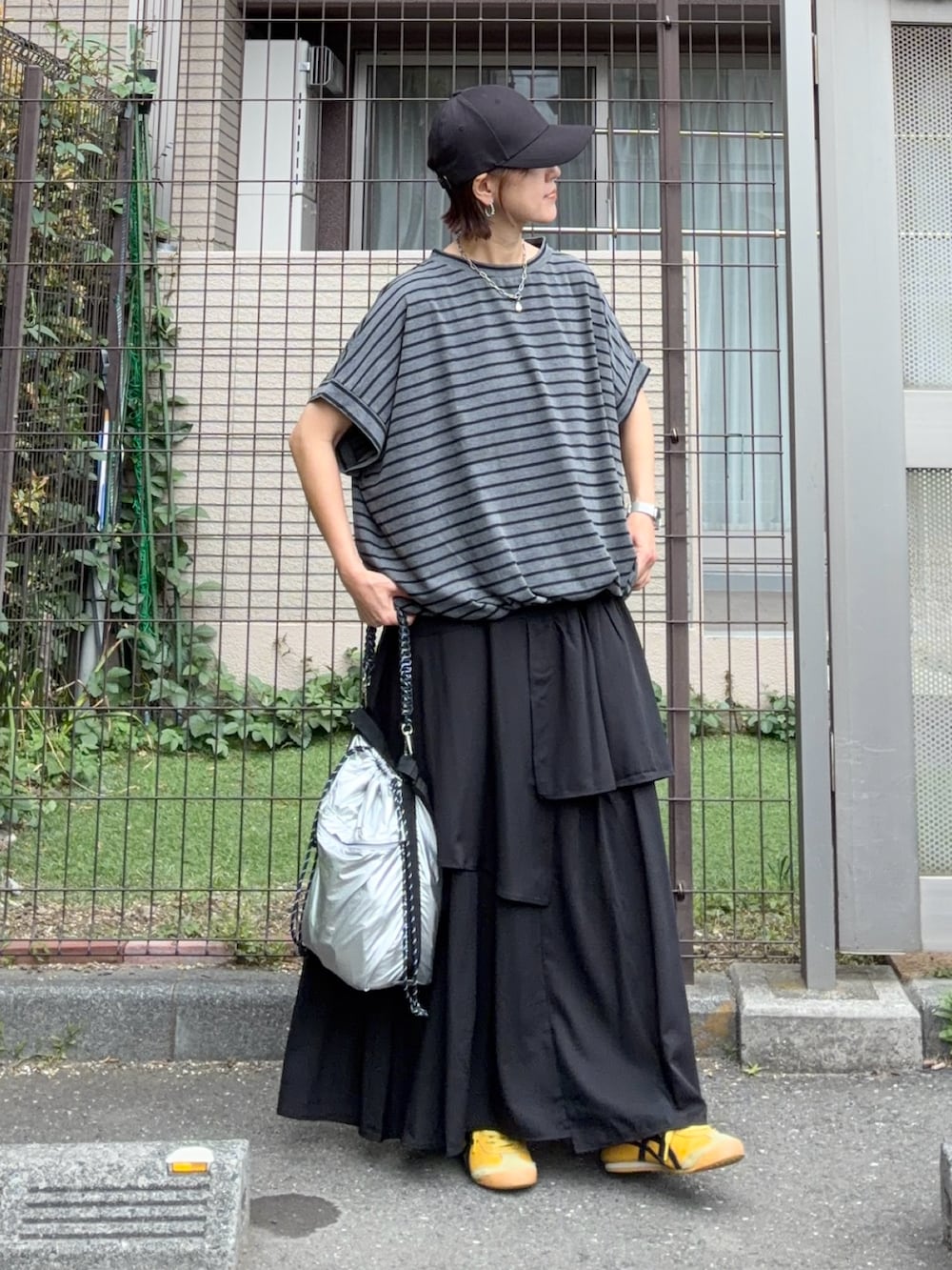 グレー系のTシャツ/カットソー、ブラック系のスカート、シルバー系のショルダーバッグを着用したレディースの夏コーディネートの2枚目の写真
