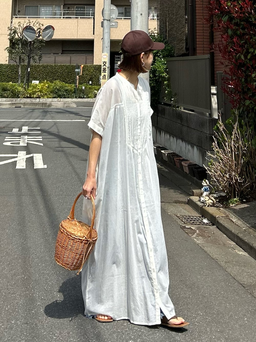 ホワイト系のワンピース、ブルー系のデニムパンツ、ブラウン系のキャップを着用したレディースの夏コーディネートの4枚目の写真
