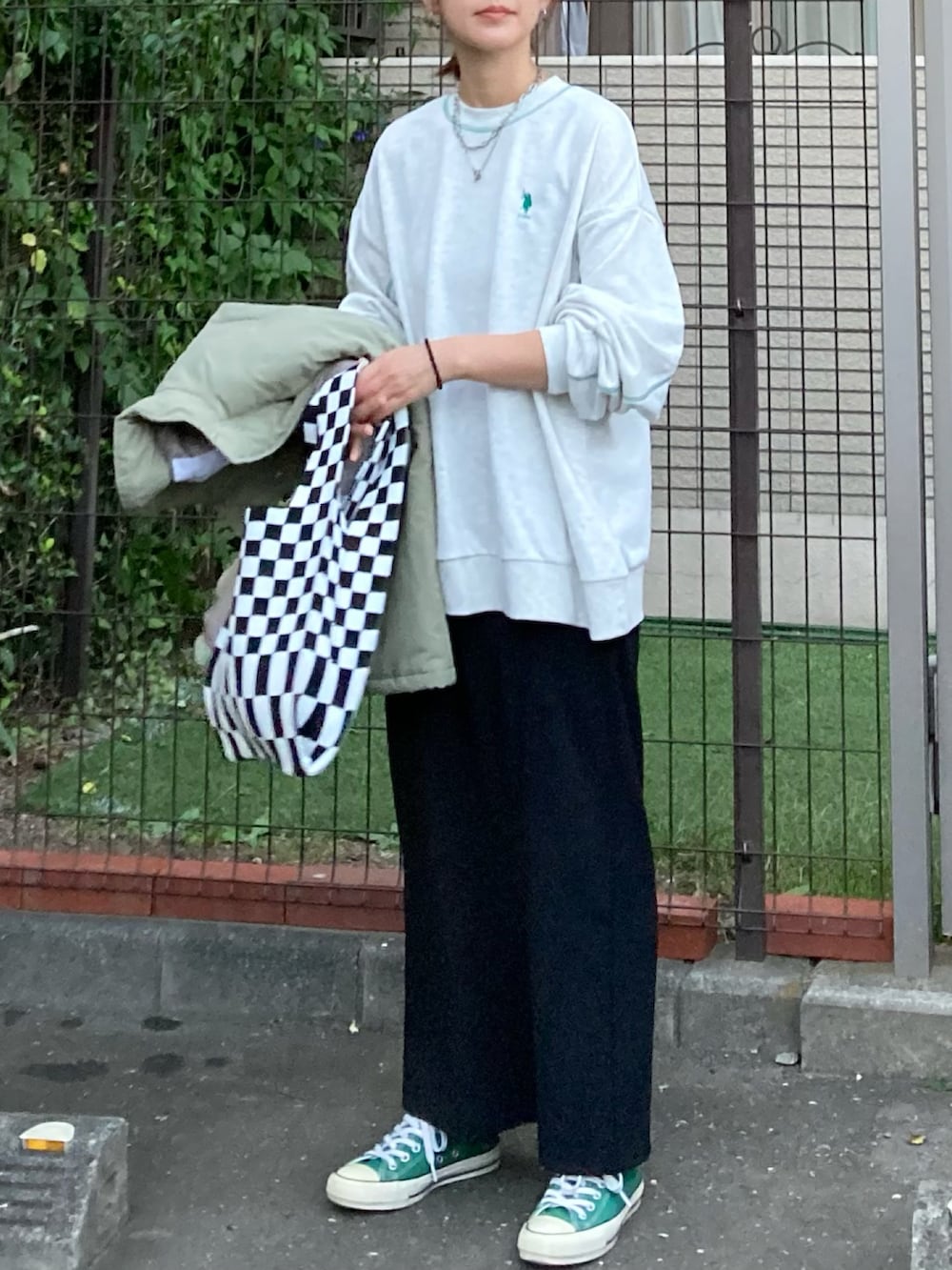 ベージュ系のスウェット、ブラック系のスカート、グリーン系のダウンジャケット/コートを着用したレディースの秋コーディネートの4枚目の写真