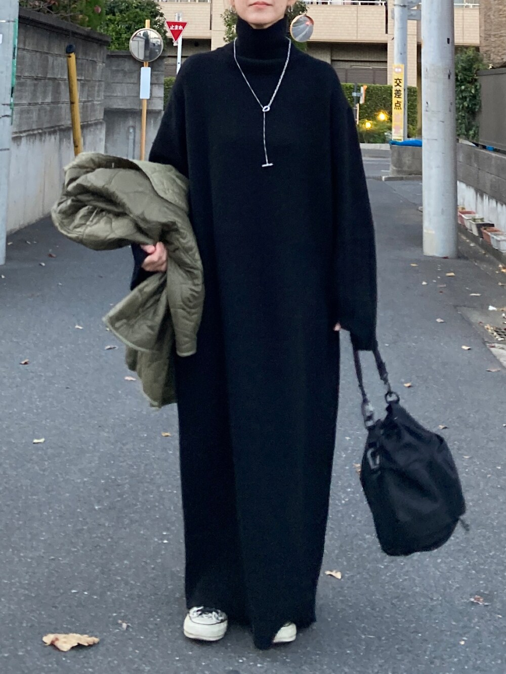 ブラック系のワンピース、ブラック系のショルダーバッグ、その他のスニーカーを着用したレディースの冬コーディネートの5枚目の写真